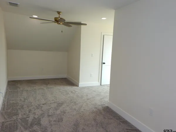 an empty room with a window and a ceiling fan
