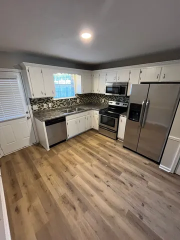 a kitchen with stainless steel appliances granite countertop a stove and a refrigerator
