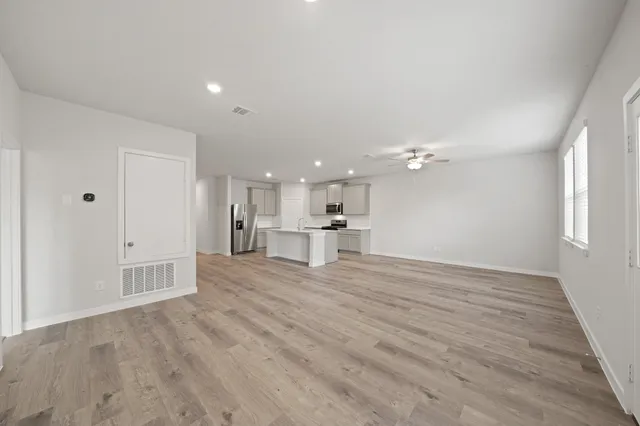 a view of a kitchen with a sink and dishwasher a refrigerator with wooden floor