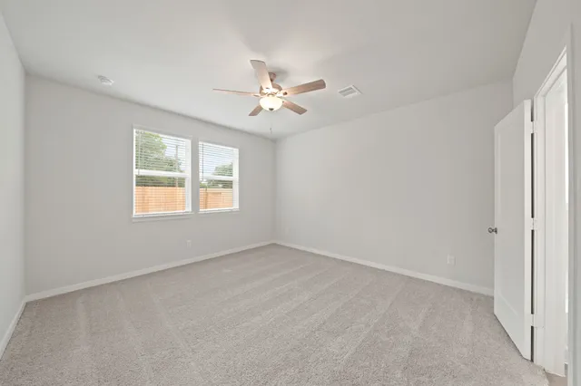 an empty room with a window and a ceiling fan