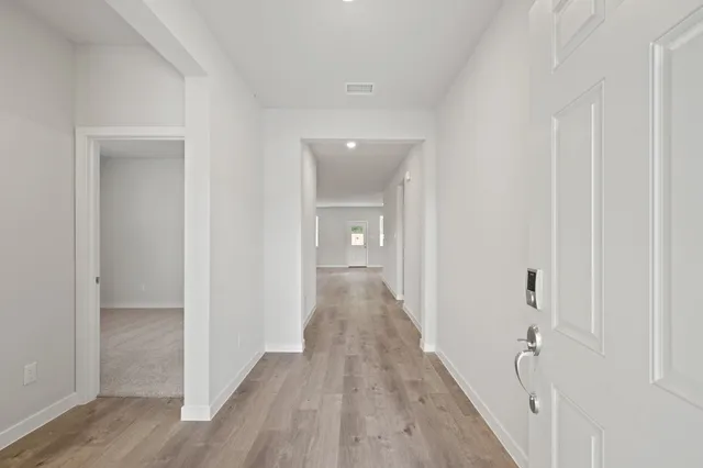 a view of a hallway with wooden floor