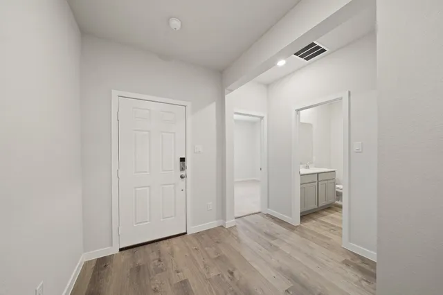 a view of empty room with wooden floor