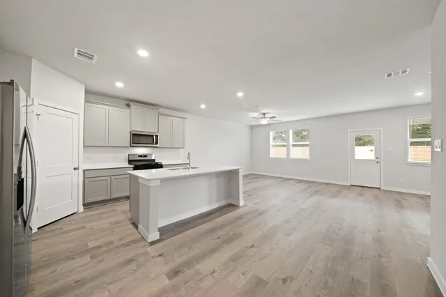 a kitchen with white cabinets and stainless steel appliances