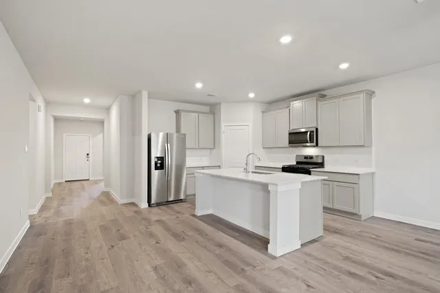 a kitchen with white cabinets and stainless steel appliances