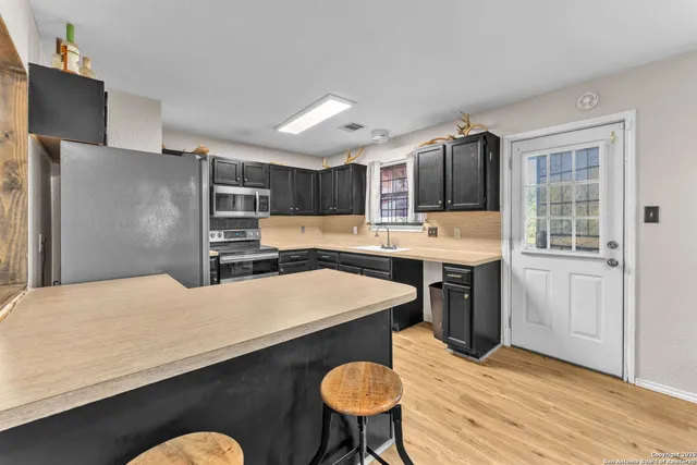 a kitchen with stainless steel appliances kitchen island granite countertop a refrigerator a stove and a sink