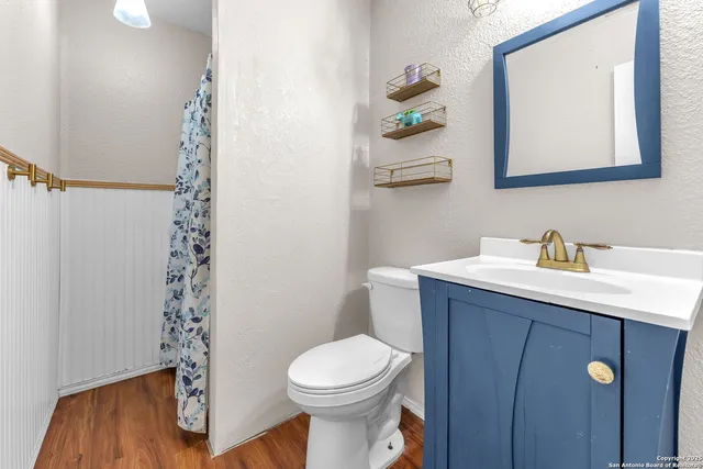 a bathroom with a toilet a sink and mirror