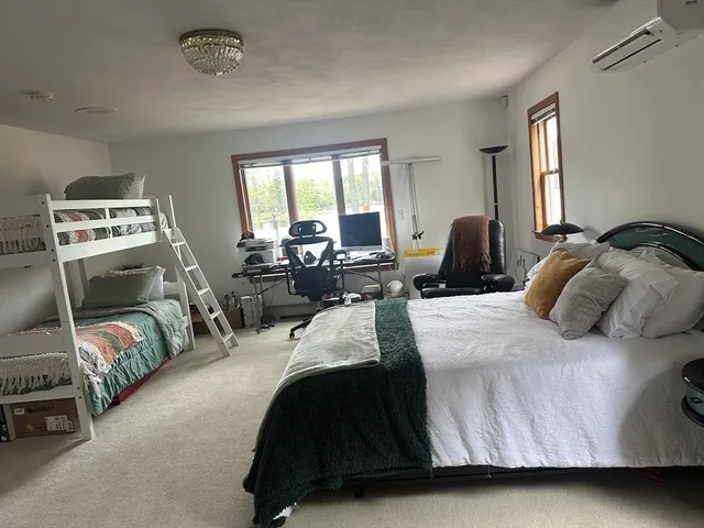 a bedroom with a bed and large windows