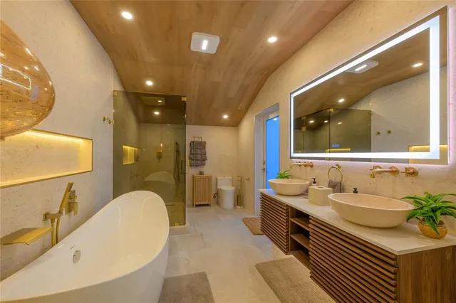 a bathroom with a granite countertop sink mirror and bathtub