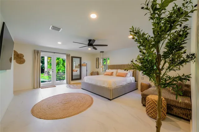 a bedroom with a large bed and a chandelier