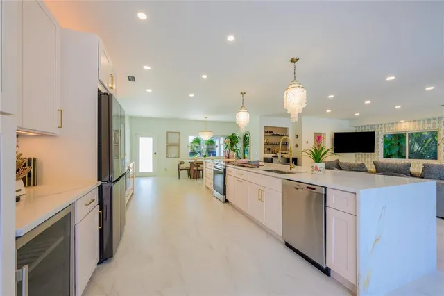 a large kitchen with kitchen island a sink stainless steel appliances and cabinets