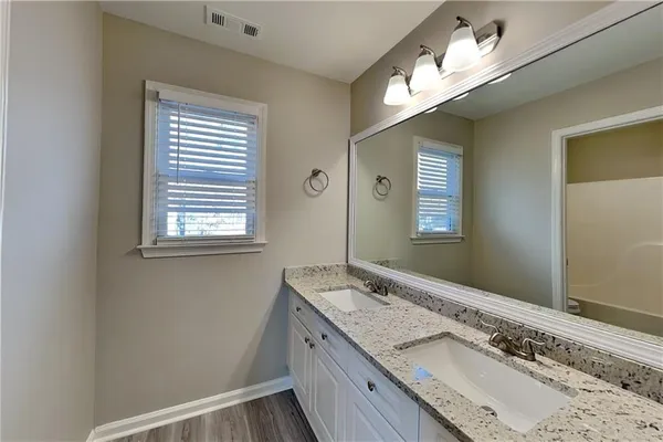 a bathroom with a granite countertop sink and a mirror
