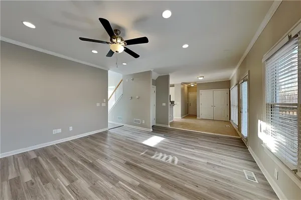 a view of an empty room and window and wooden floor
