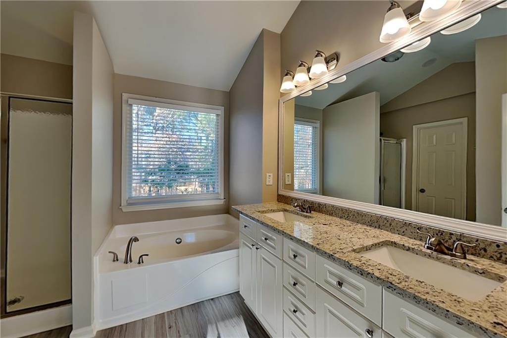 149 Crestview Drive Dallas, GA 30157 - Photo 10 of 24 a bathroom with a granite countertop tub a double vanity sink and a large mirror
