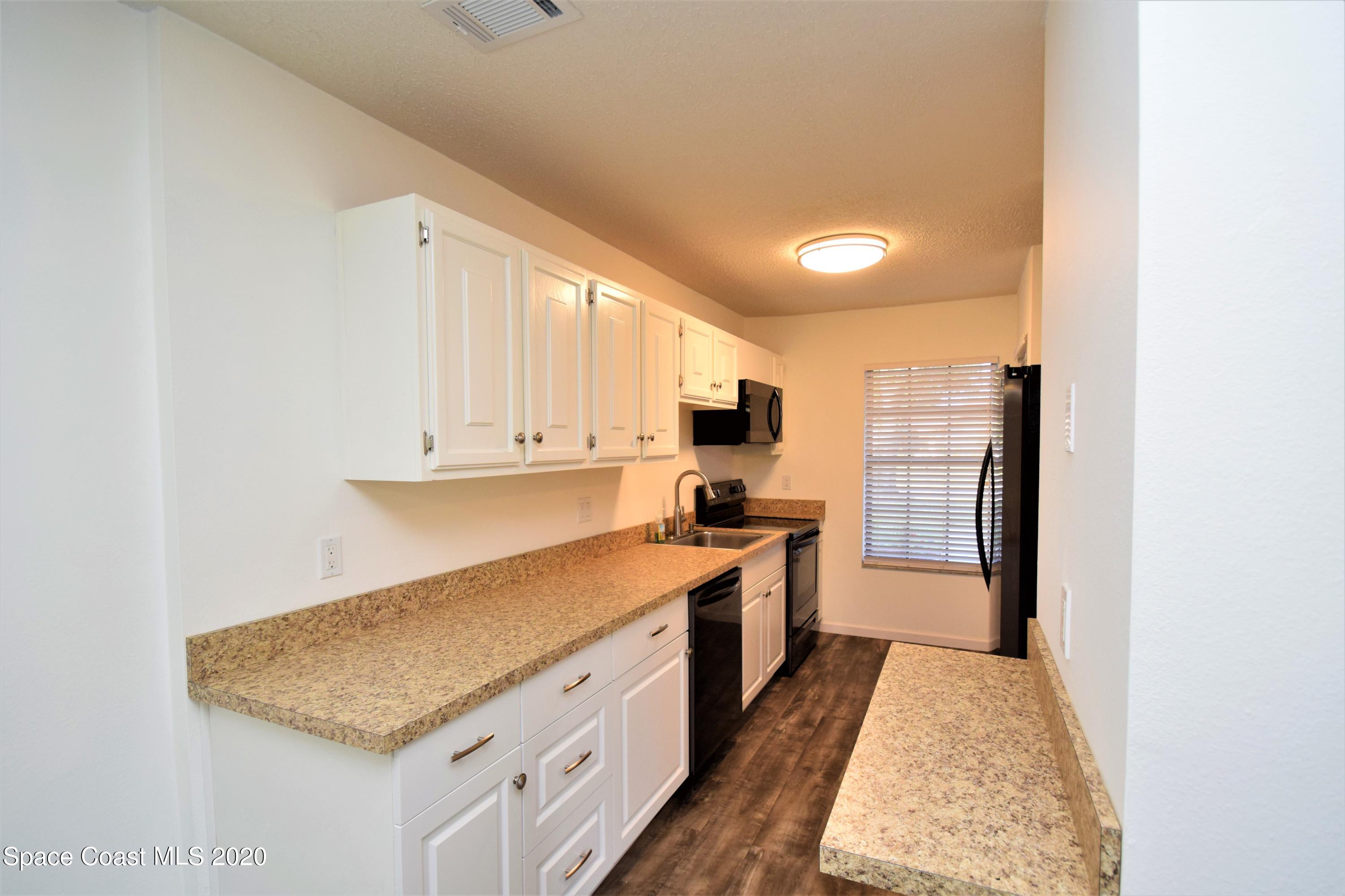 1654 Dawes Road Northeast Palm Bay, FL 32905 - Photo 11 of 47 a kitchen with stainless steel appliances granite countertop a sink stove and refrigerator