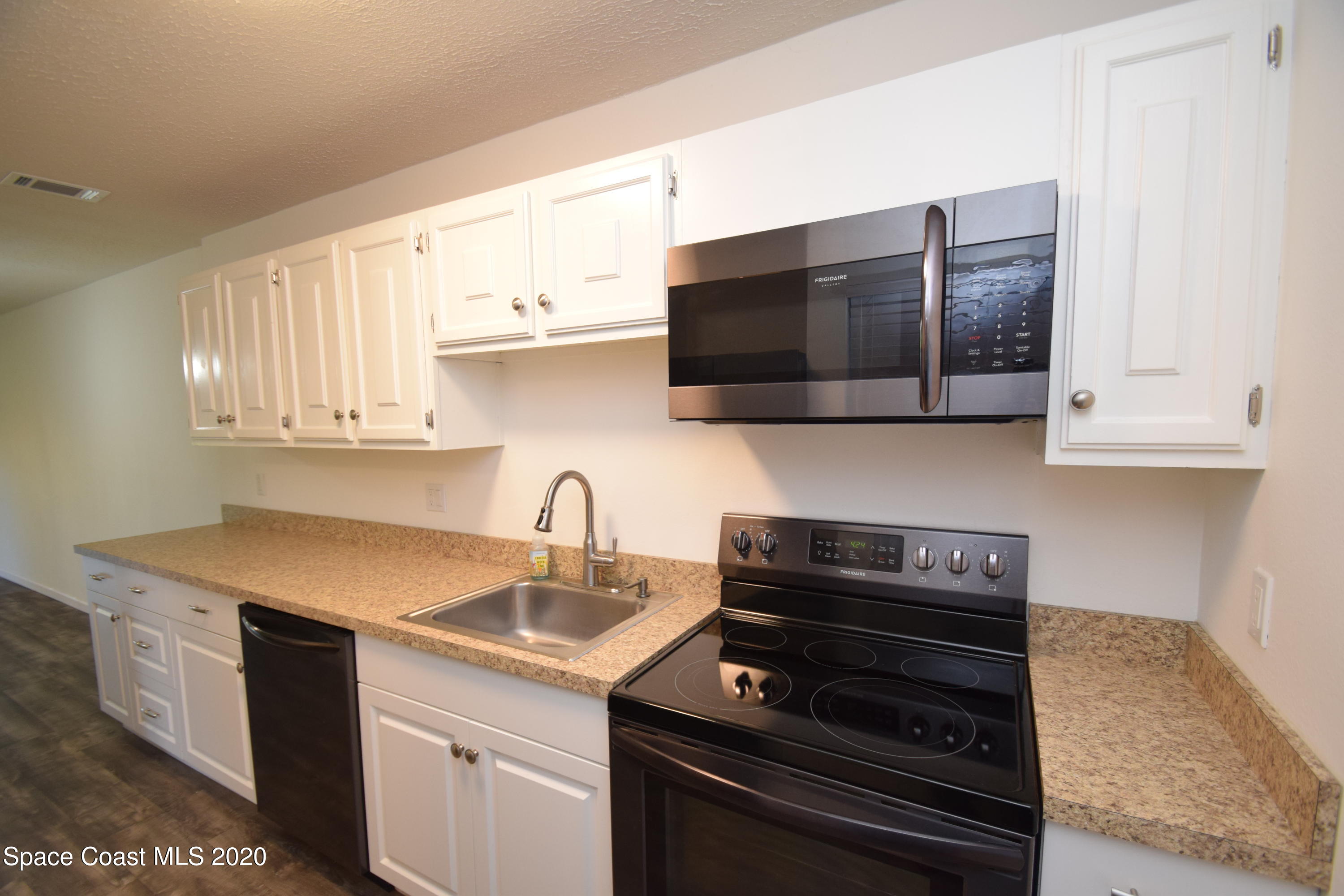 1654 Dawes Road Northeast Palm Bay, FL 32905 - Photo 13 of 47 a kitchen with a sink stove and microwave