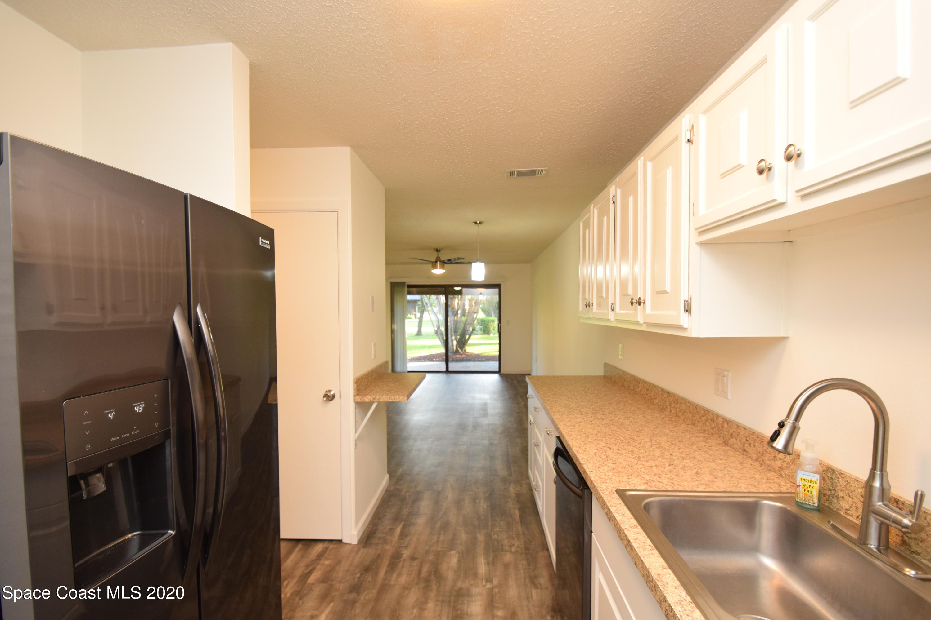 1654 Dawes Road Northeast Palm Bay, FL 32905 - Photo 15 of 47 a kitchen with stainless steel appliances granite countertop a refrigerator a sink and wooden floors