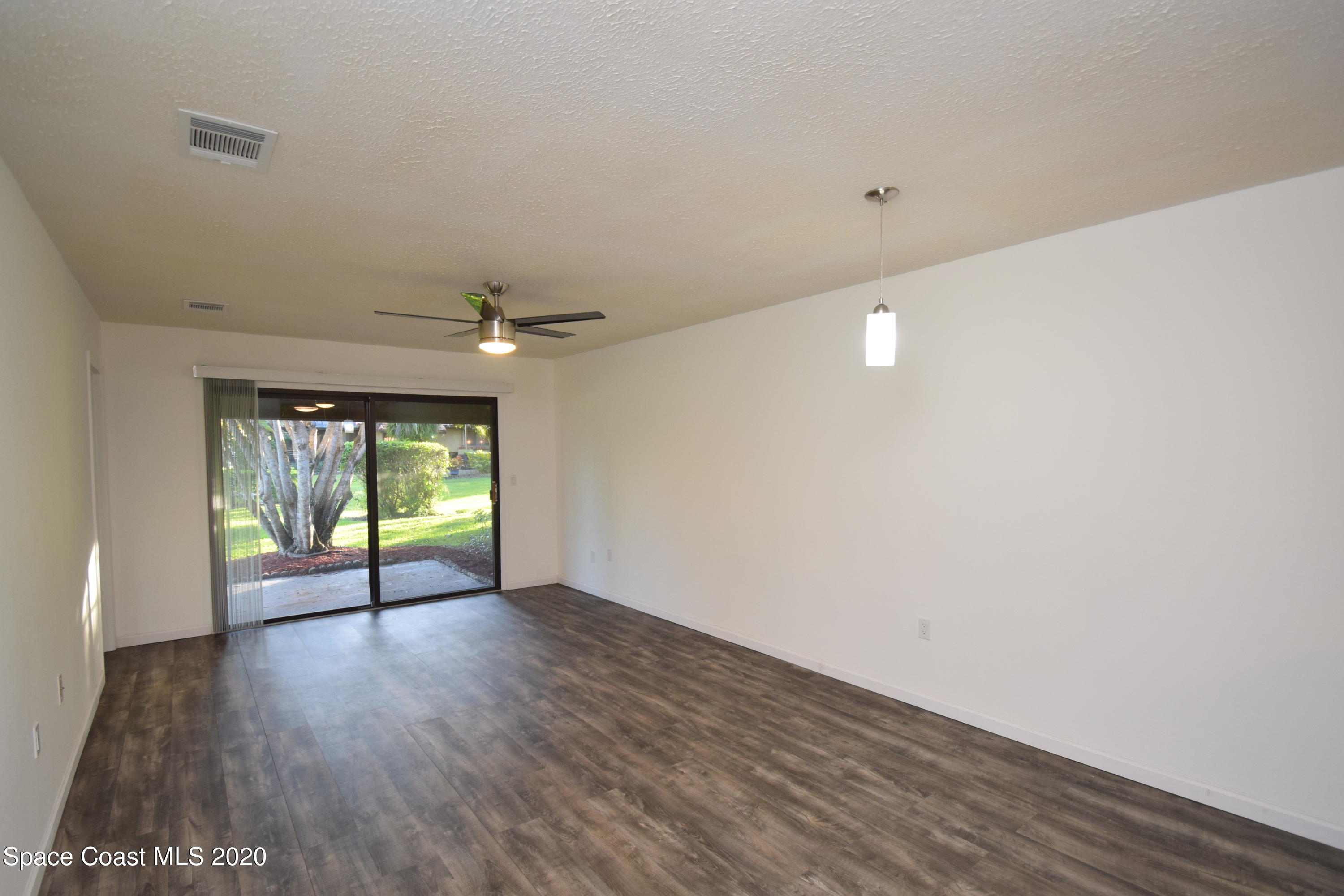 1654 Dawes Road Northeast Palm Bay, FL 32905 - Photo 17 of 47 an empty room with wooden floor and windows