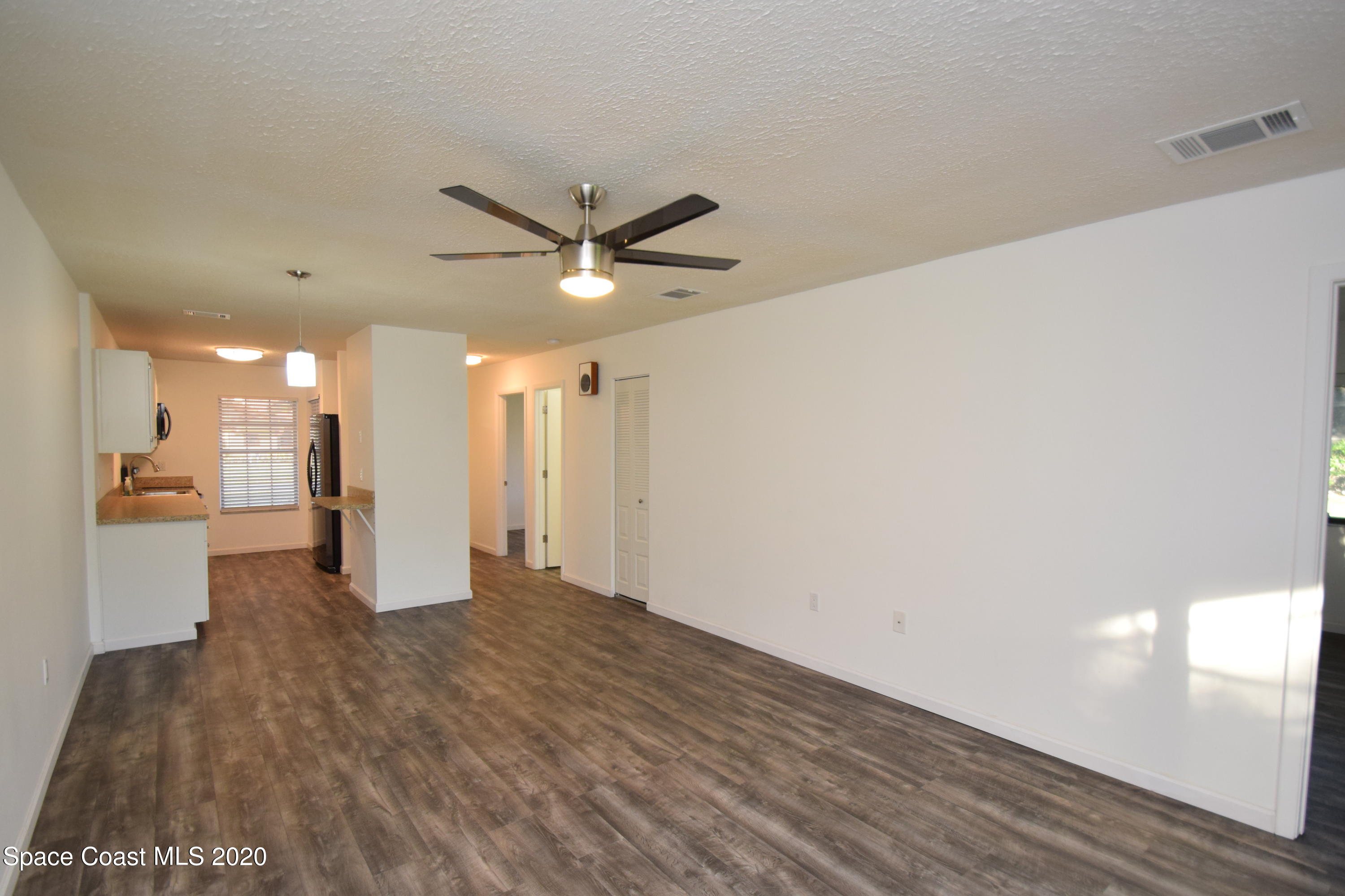 1654 Dawes Road Northeast Palm Bay, FL 32905 - Photo 21 of 47 a view of an empty room with wooden floor and a window
