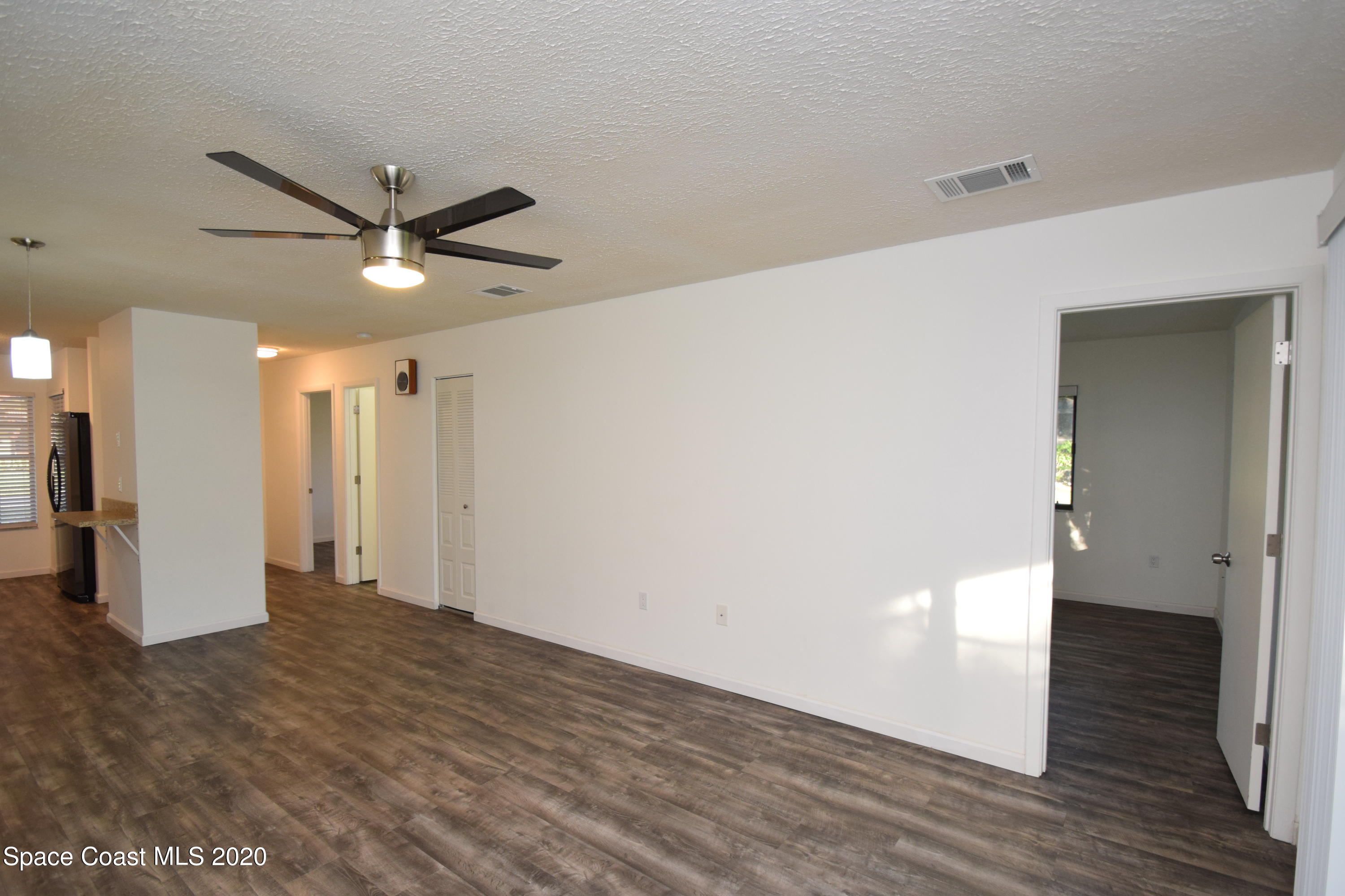 1654 Dawes Road Northeast Palm Bay, FL 32905 - Photo 22 of 47 a view of a livingroom with a ceiling fan & wooden floor