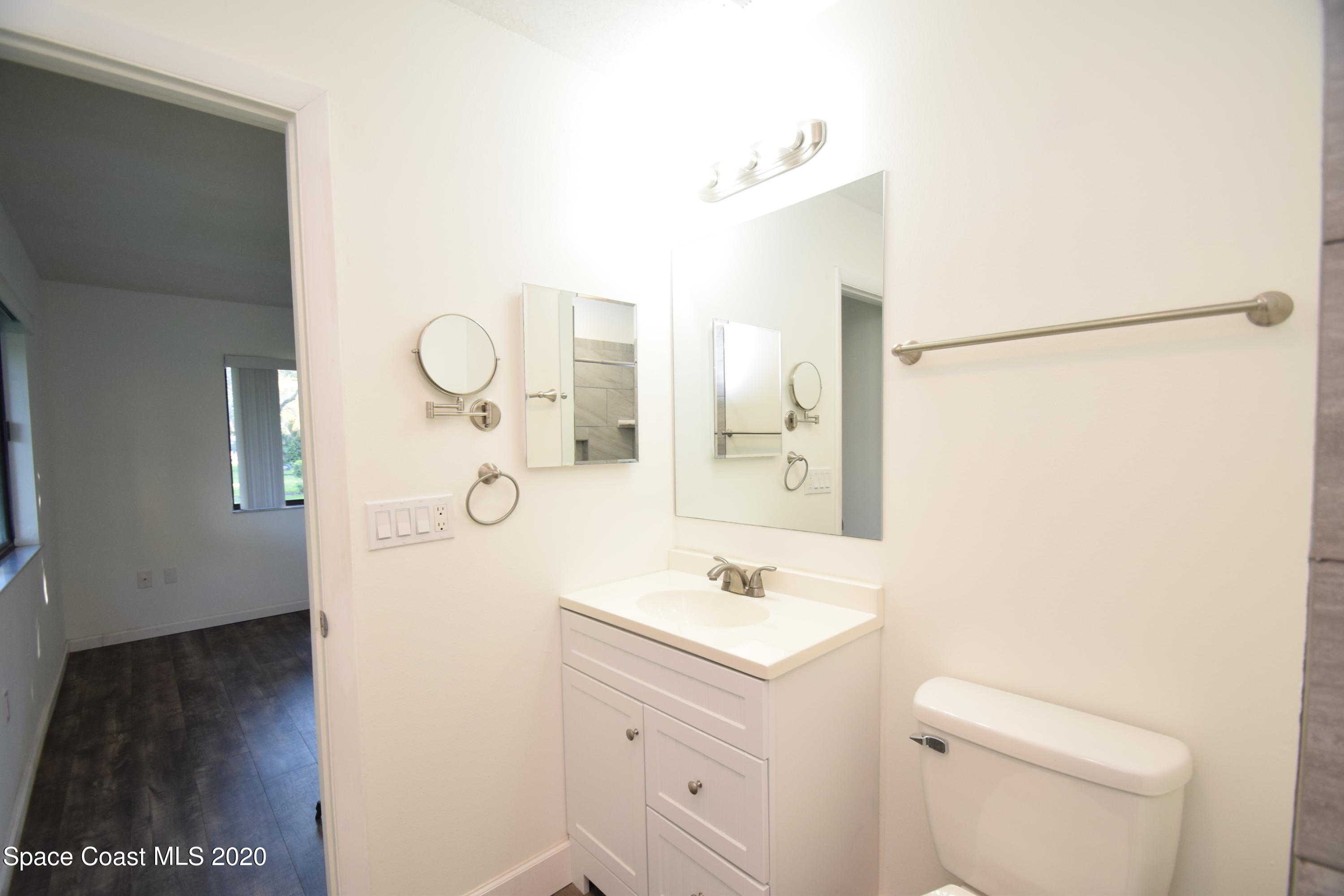 1654 Dawes Road Northeast Palm Bay, FL 32905 - Photo 30 of 47 a bathroom with a sink a toilet and a mirror
