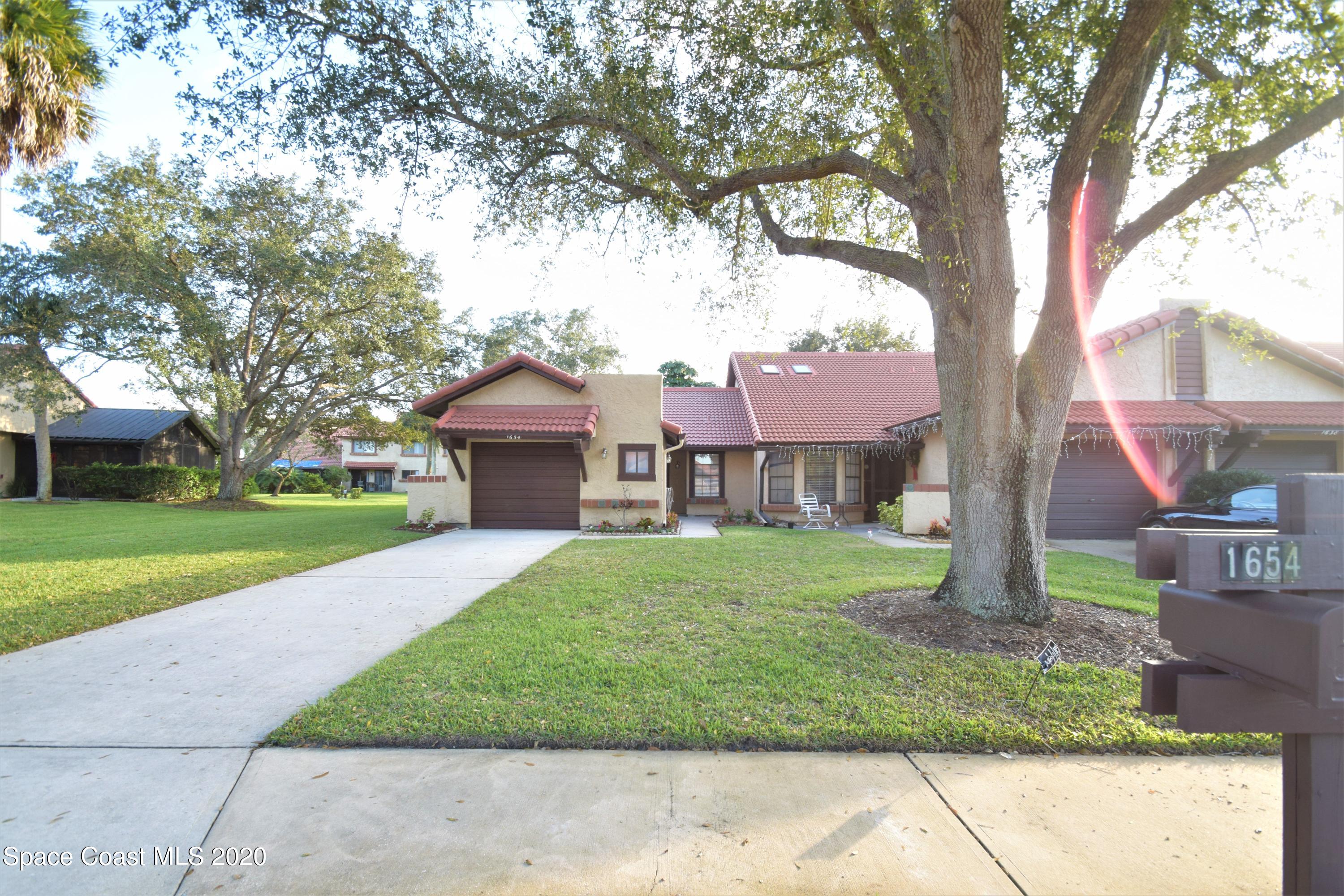 1654 Dawes Road Northeast Palm Bay, FL 32905 - Photo 4 of 47 a front view of a house with garden