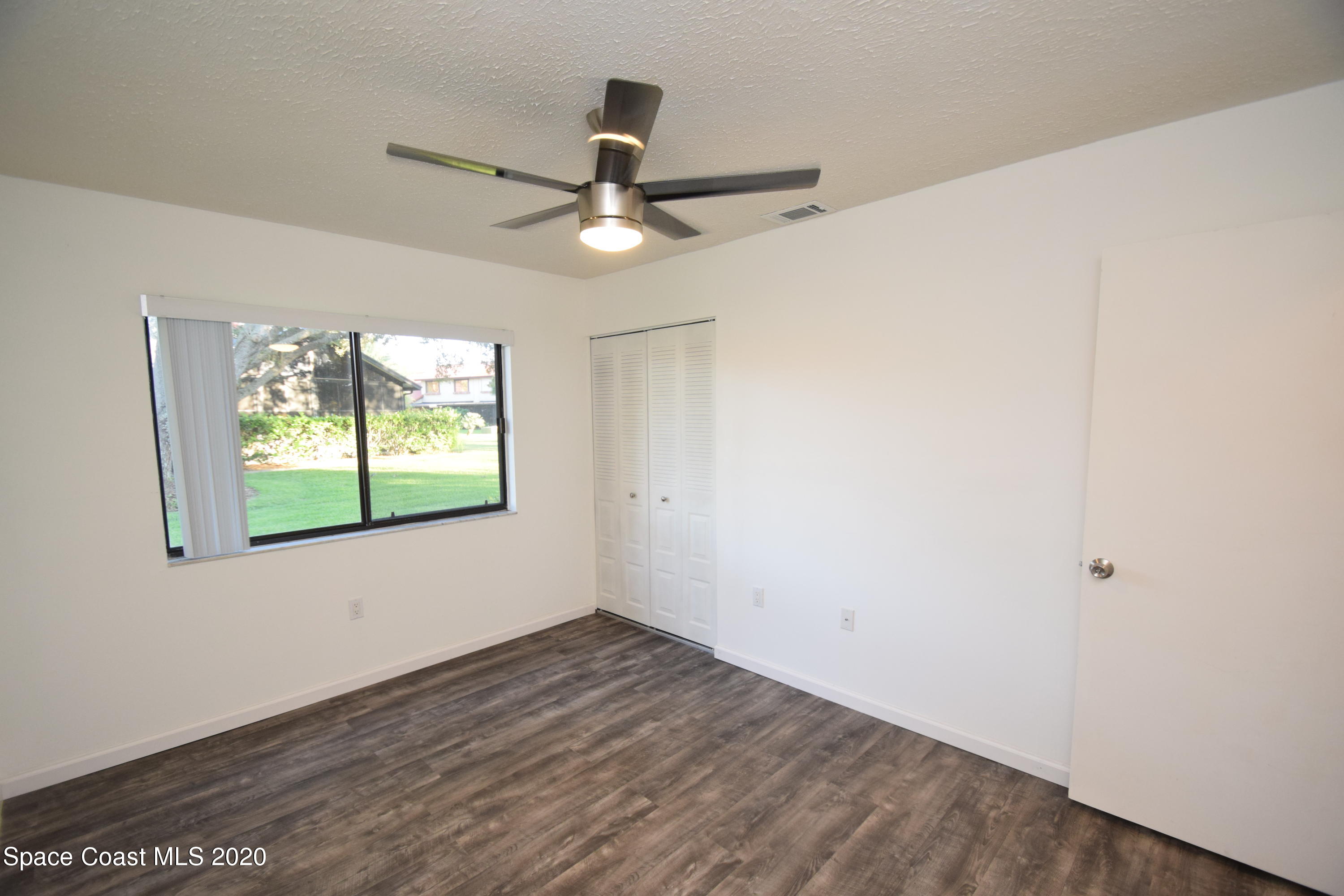 1654 Dawes Road Northeast Palm Bay, FL 32905 - Photo 32 of 47 an empty room with a window and a ceiling fan