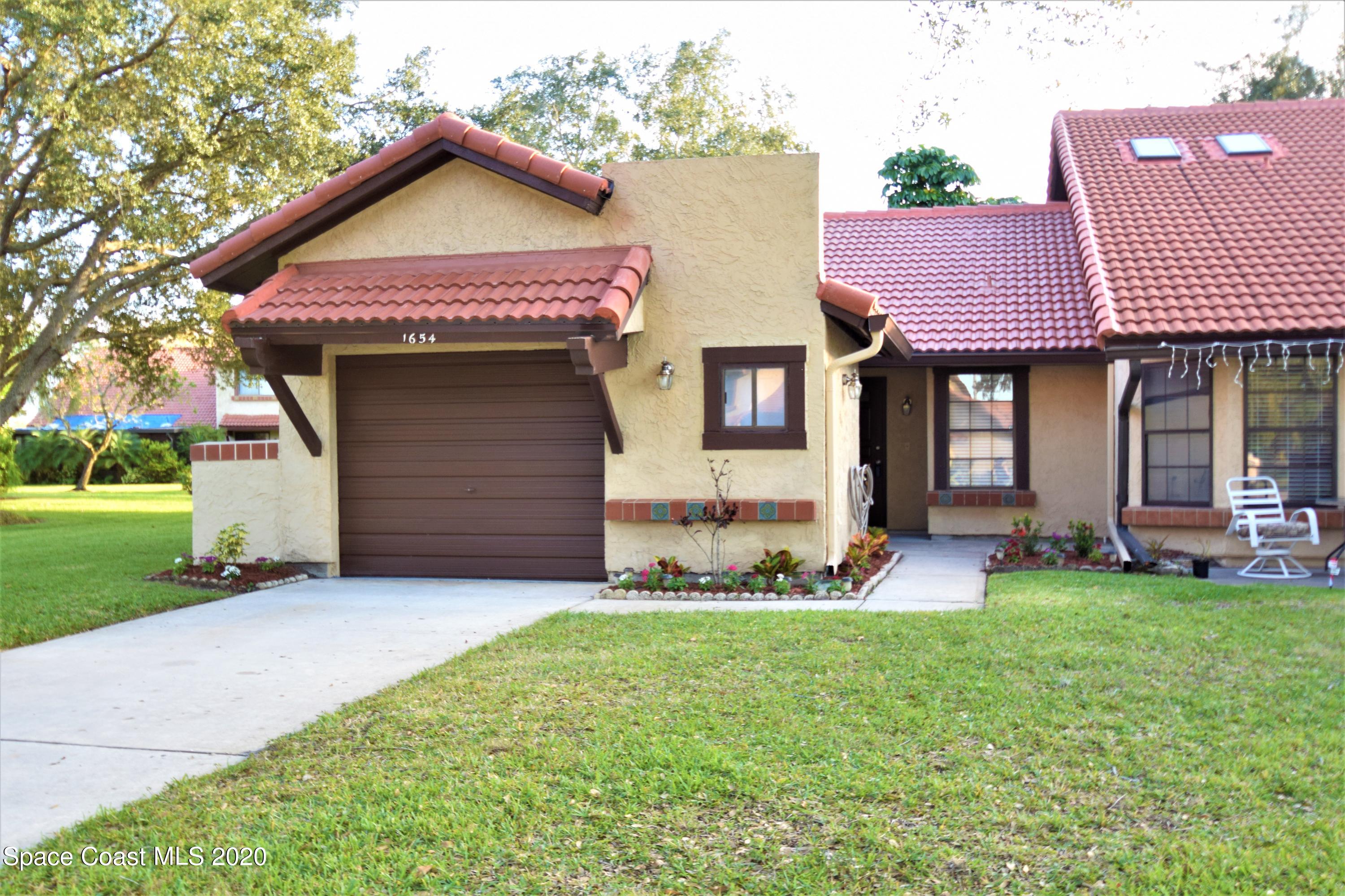 1654 Dawes Road Northeast Palm Bay, FL 32905 - Photo 5 of 47 a front view of a house with a yard and garage