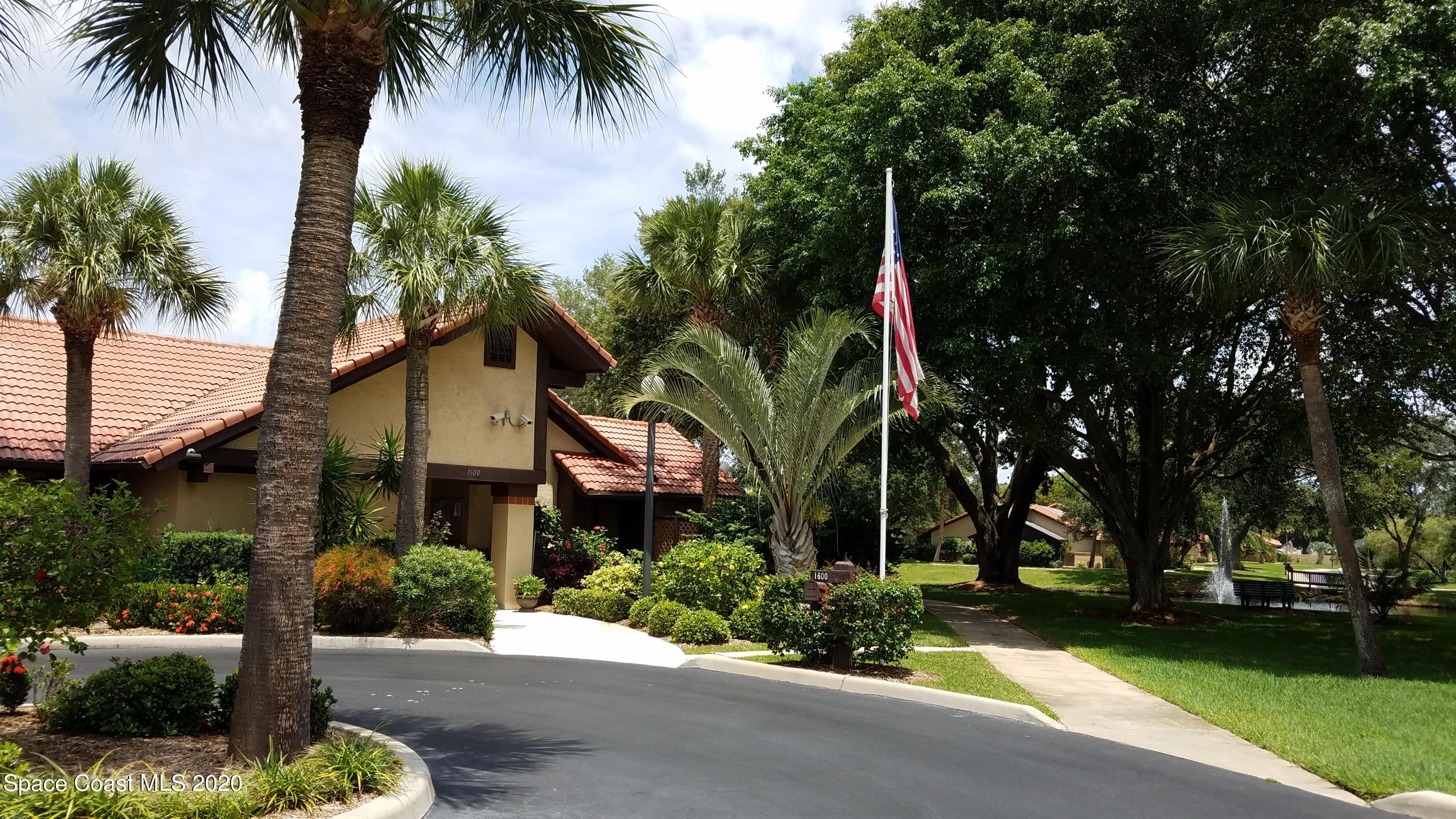 1654 Dawes Road Northeast Palm Bay, FL 32905 - Photo 45 of 47 a front view of a house with a garden and trees