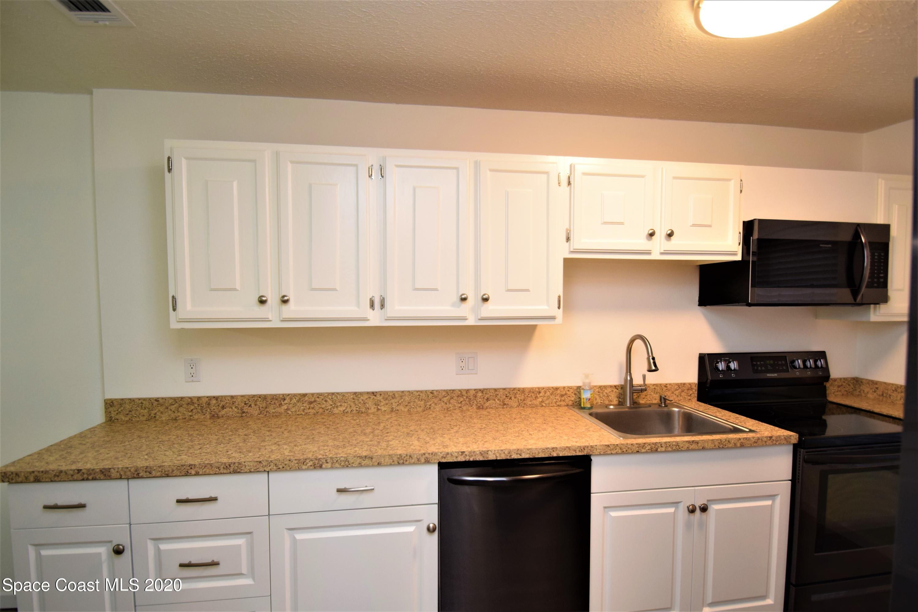 1654 Dawes Road Northeast Palm Bay, FL 32905 - Photo 10 of 47 a kitchen with granite countertop a sink and cabinets