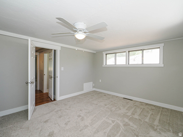 154 East 3000th Street South Bountiful, UT 84010 - Photo 16 of 37 Neutral-toned room featuring a white ceiling fan with integrated lighting, multiple windows with white trim, and plush carpeting