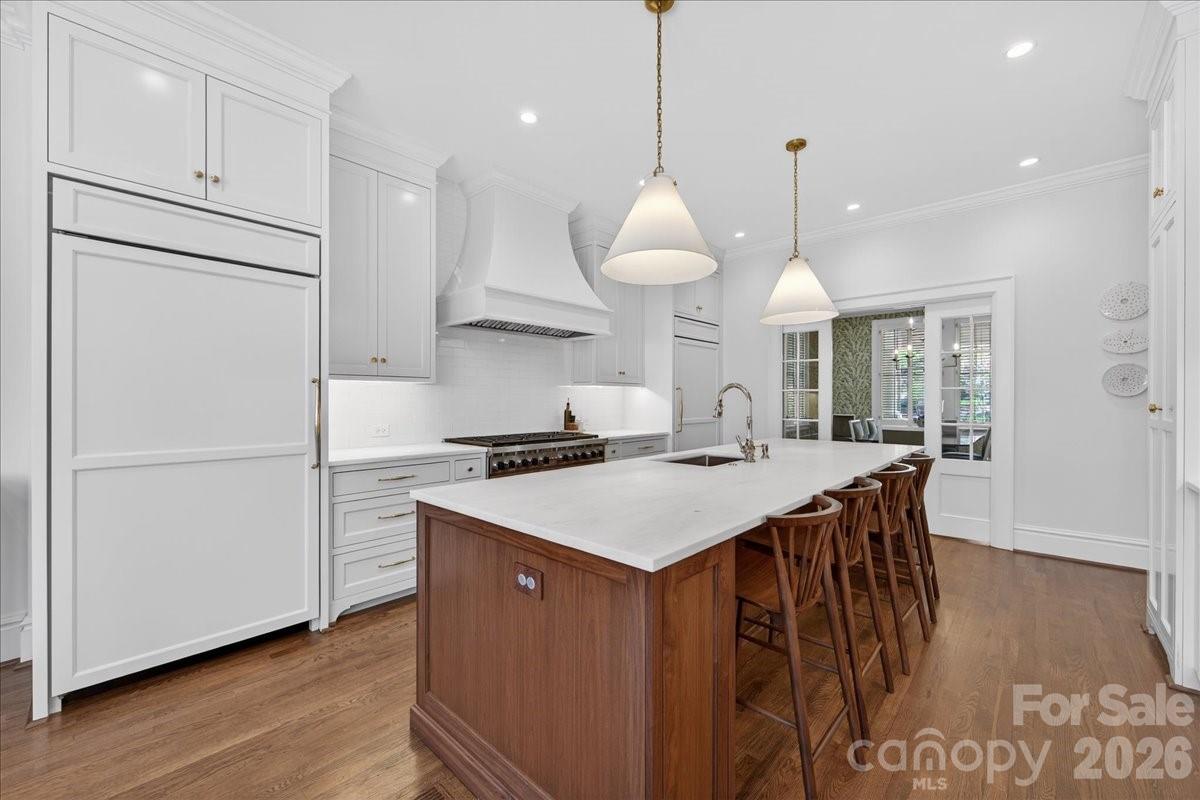 700 Queens Road Charlotte, NC 28207 - Photo 16 of 41 a kitchen with stainless steel appliances granite countertop a sink a stove a refrigerator and island with wooden floor