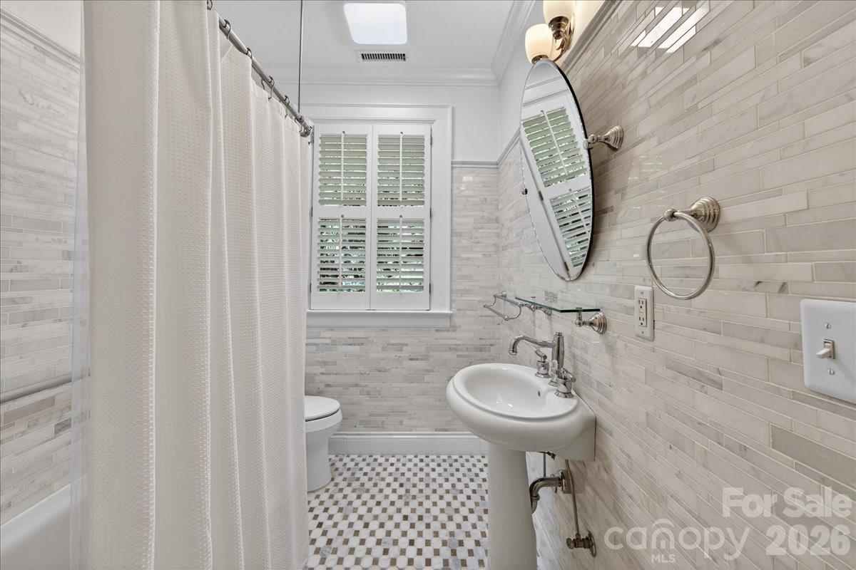 700 Queens Road Charlotte, NC 28207 - Photo 33 of 41 a bathroom with a sink toilet and a mirror