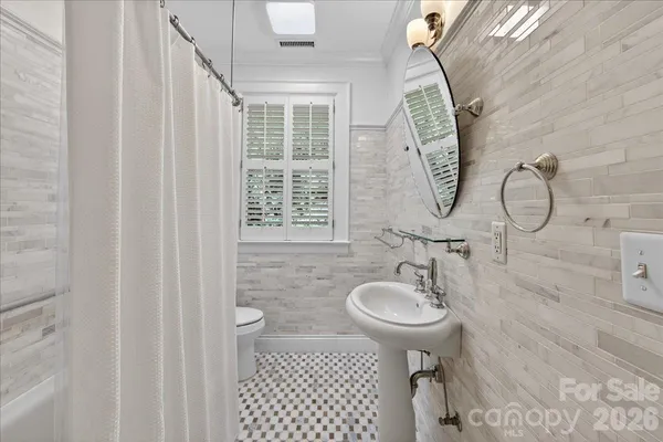 a bathroom with a sink toilet and a mirror