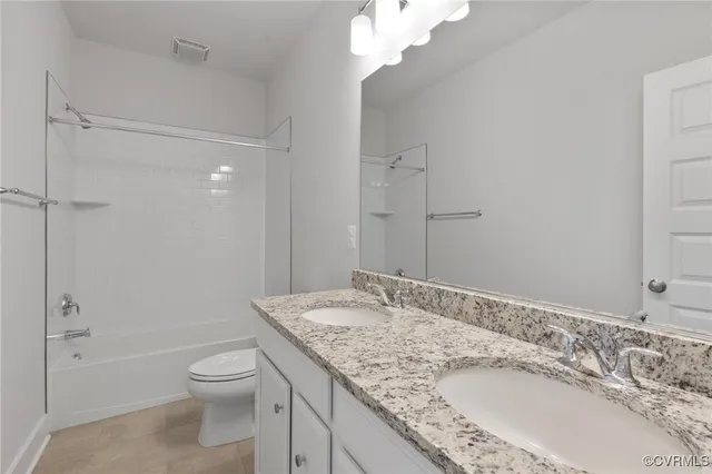 a bathroom with a granite countertop sink a toilet and shower
