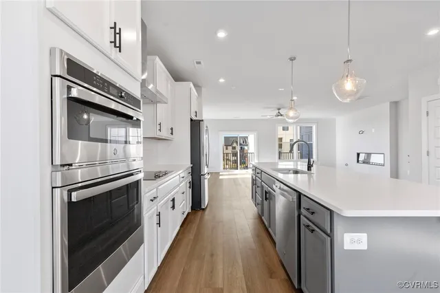 a large kitchen with stainless steel appliances granite countertop a lot of counter space and wooden floors