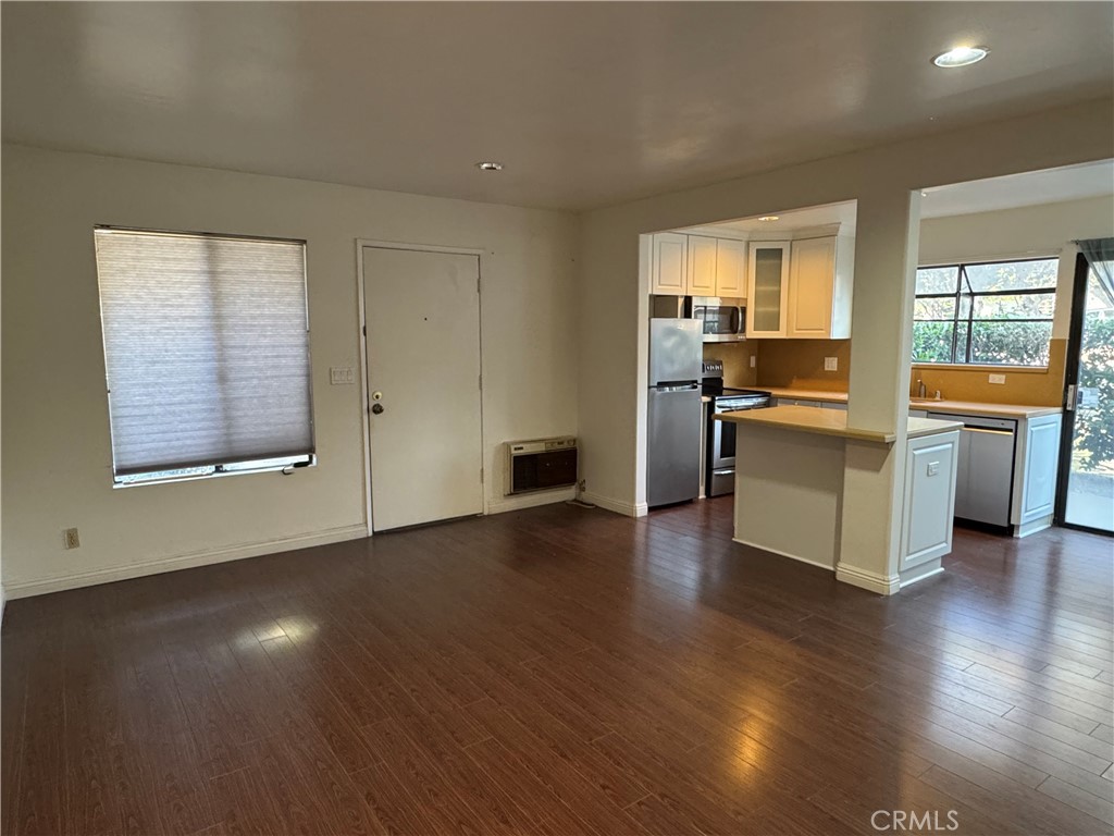 211 Springview Irvine, CA 92620 - Photo 3 of 12 a view of a kitchen with a stove wooden cabinets and a living room