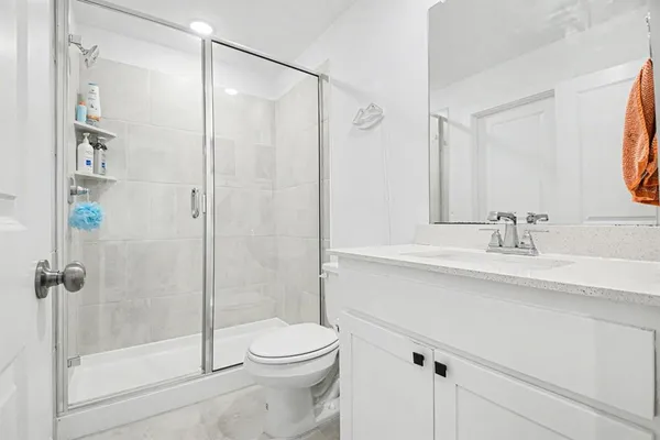 a bathroom with a sink a toilet and shower