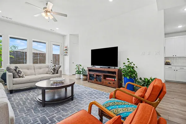 a living room with furniture a flat screen tv and a window