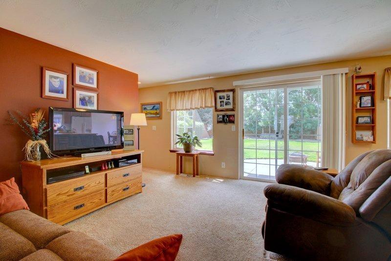 557 Mitchell Way Central Point, OR 97502 - Photo 3 of 23 a living room with furniture a flat screen tv and a floor to ceiling window