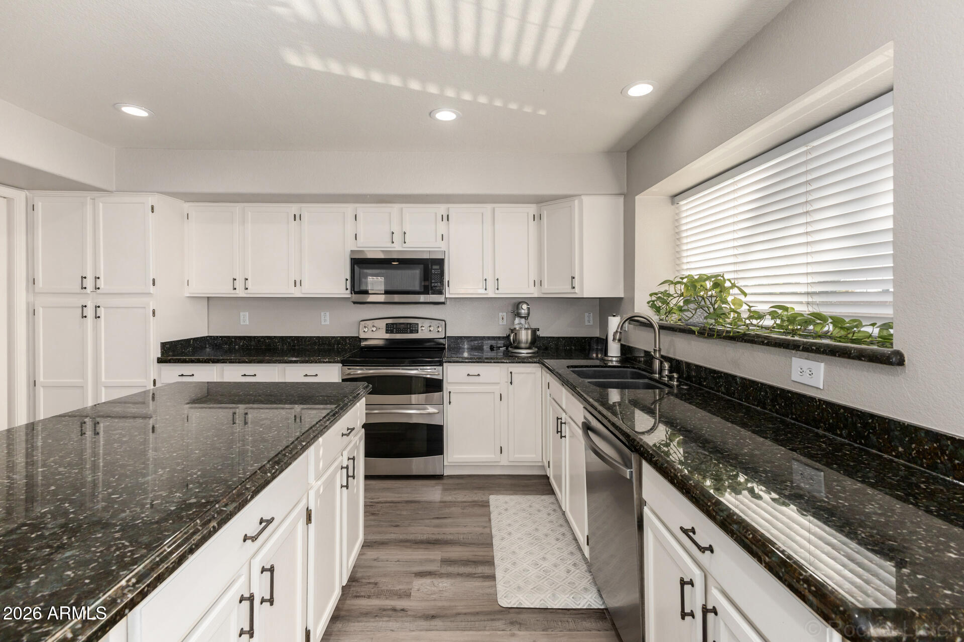 314 South Sandstone Street Gilbert, AZ 85296 - Photo 25 of 58 a large kitchen with granite countertop a stove sink and cabinets