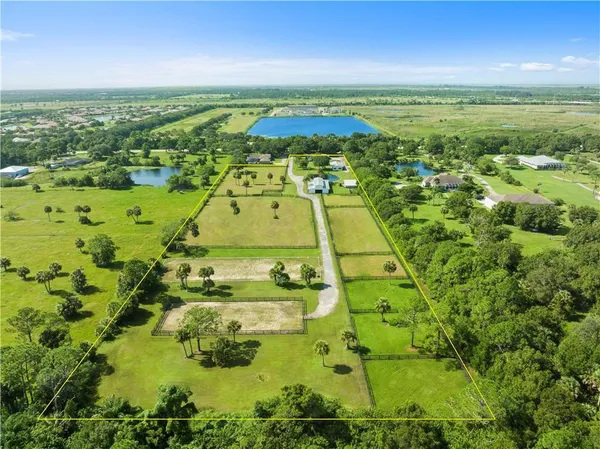an aerial view of residential houses with outdoor space and trees all around