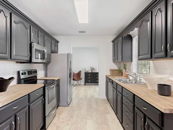 a kitchen with stainless steel appliances granite countertop a sink stove and refrigerator