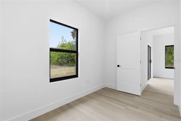 an empty room with wooden floor and a window