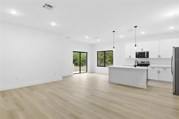 a view of kitchen with stainless steel appliances refrigerator oven microwave and stove