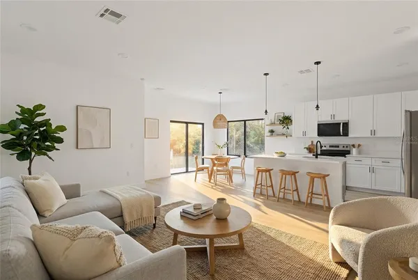 a living room with furniture a rug and a dining table