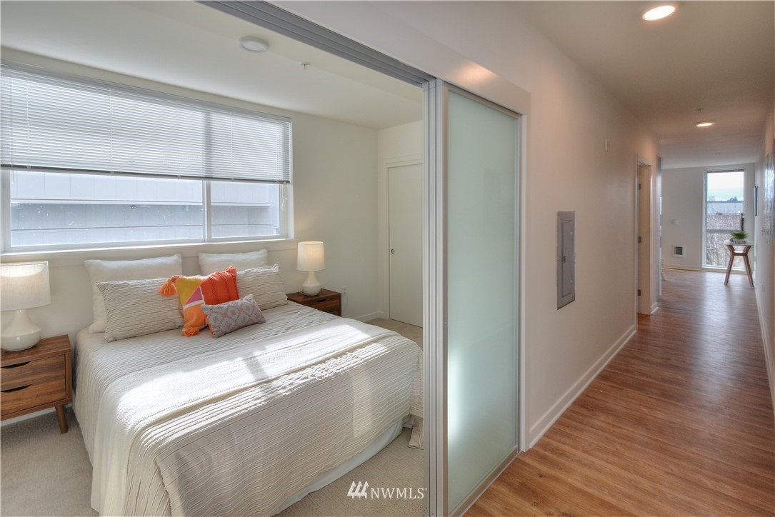 1601 North 45th Street, Unit 411 Seattle, WA 98103 - Photo 16 of 33 a bedroom with a bed and wooden floor