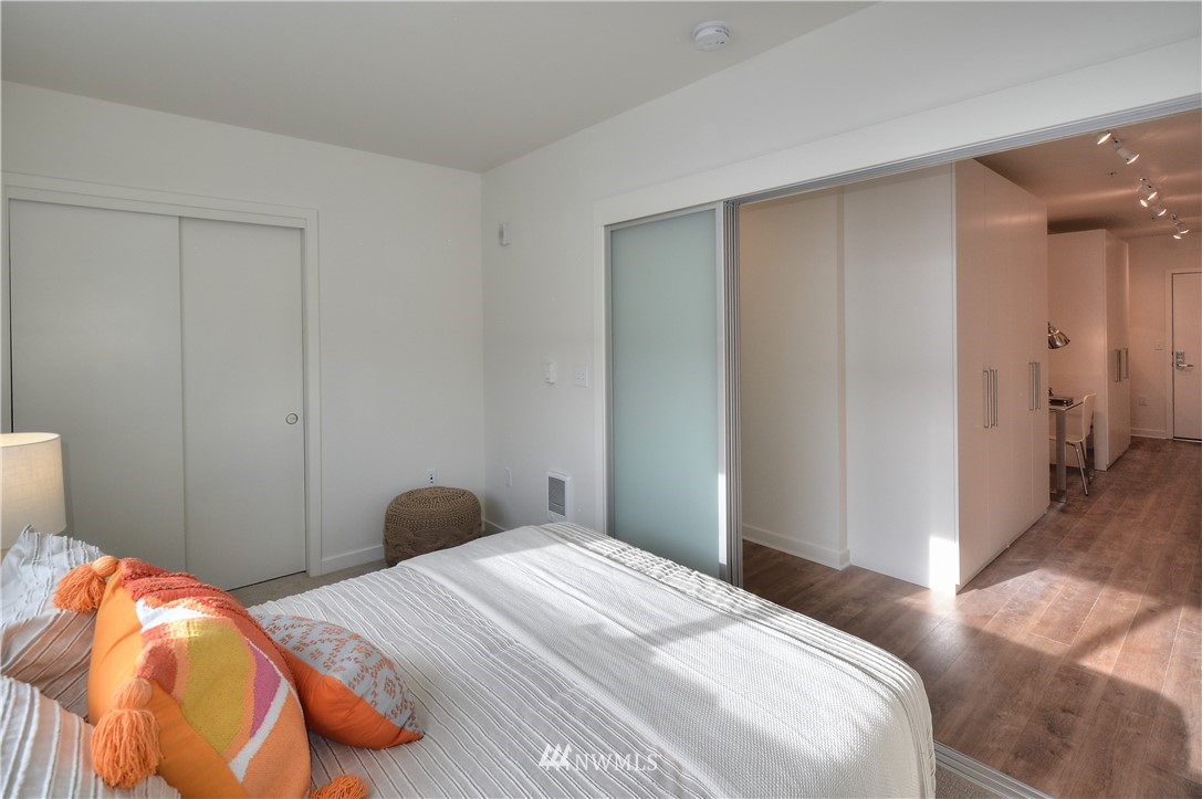 1601 North 45th Street, Unit 411 Seattle, WA 98103 - Photo 29 of 33 a bedroom with a bed and wooden floor