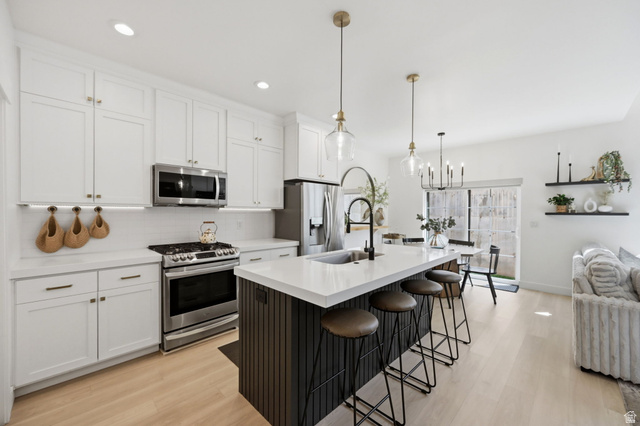 57 McCall Ln. Farmington, UT 84025 - Photo 6 of 36 Contemporary kitchen featuring white shaker cabinetry, stainless steel appliances, and a central island with a white quartz countertop