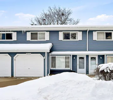 a front view of a house with a yard and parking space