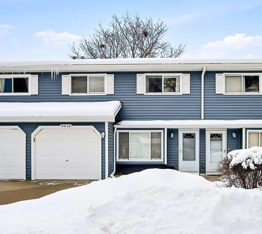 a front view of a house with a yard and parking space